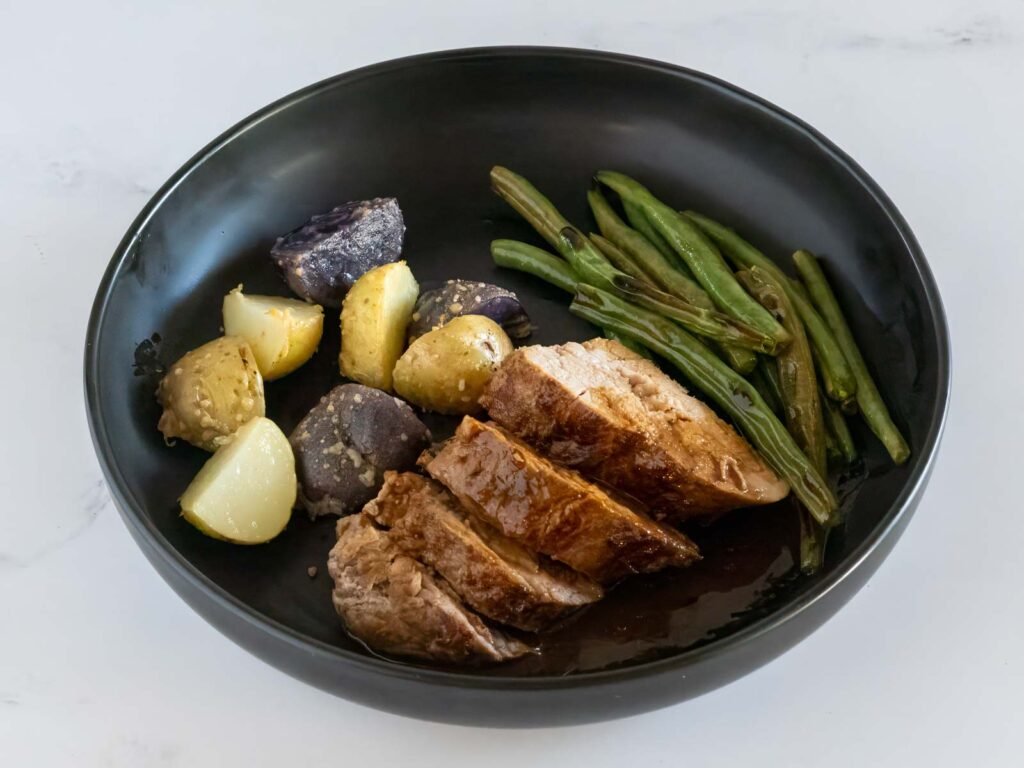 Plated pork tenderloin with green beans and baby potatoes