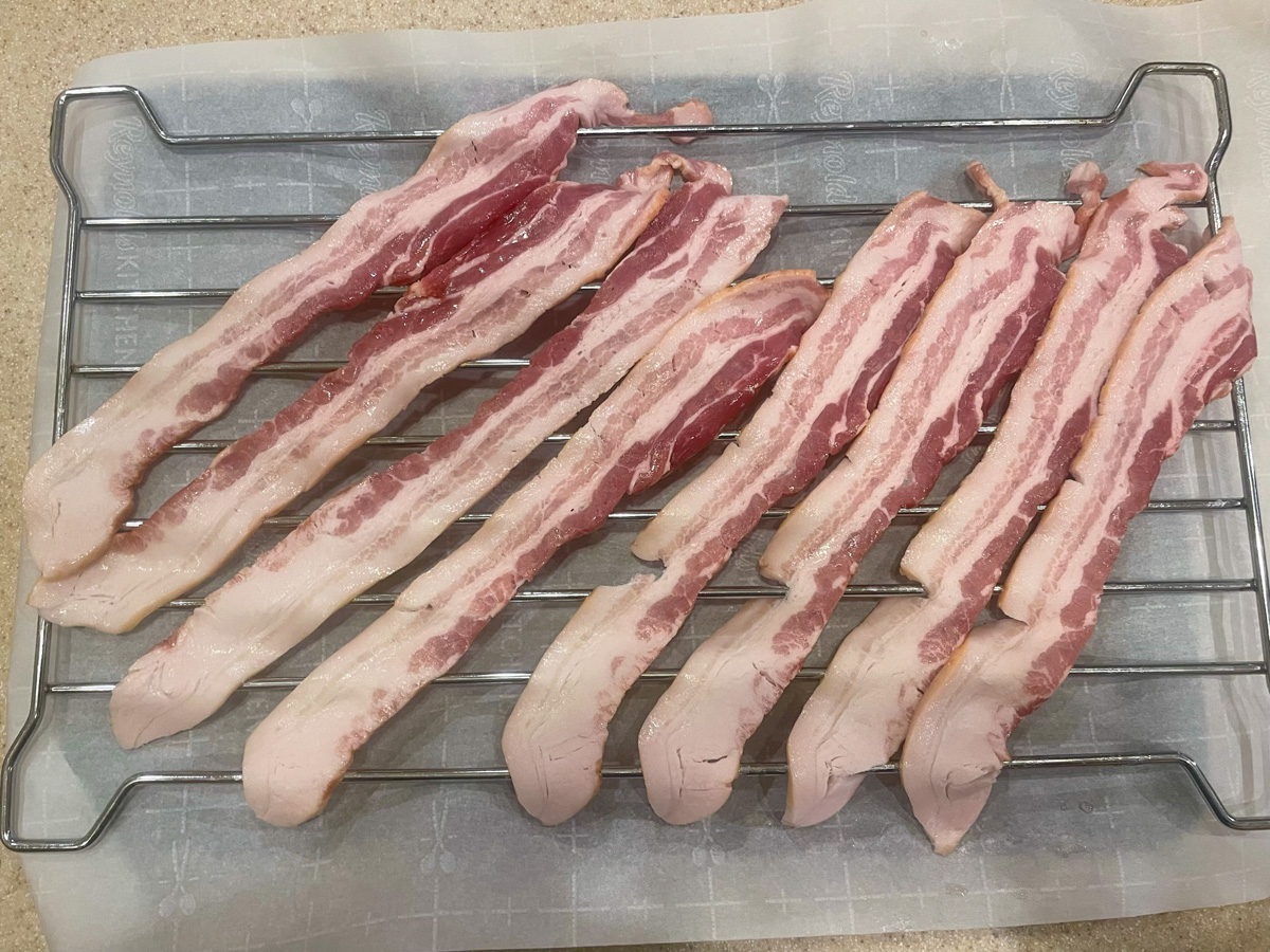 Step 2, uncooked bacon laid out on a rack