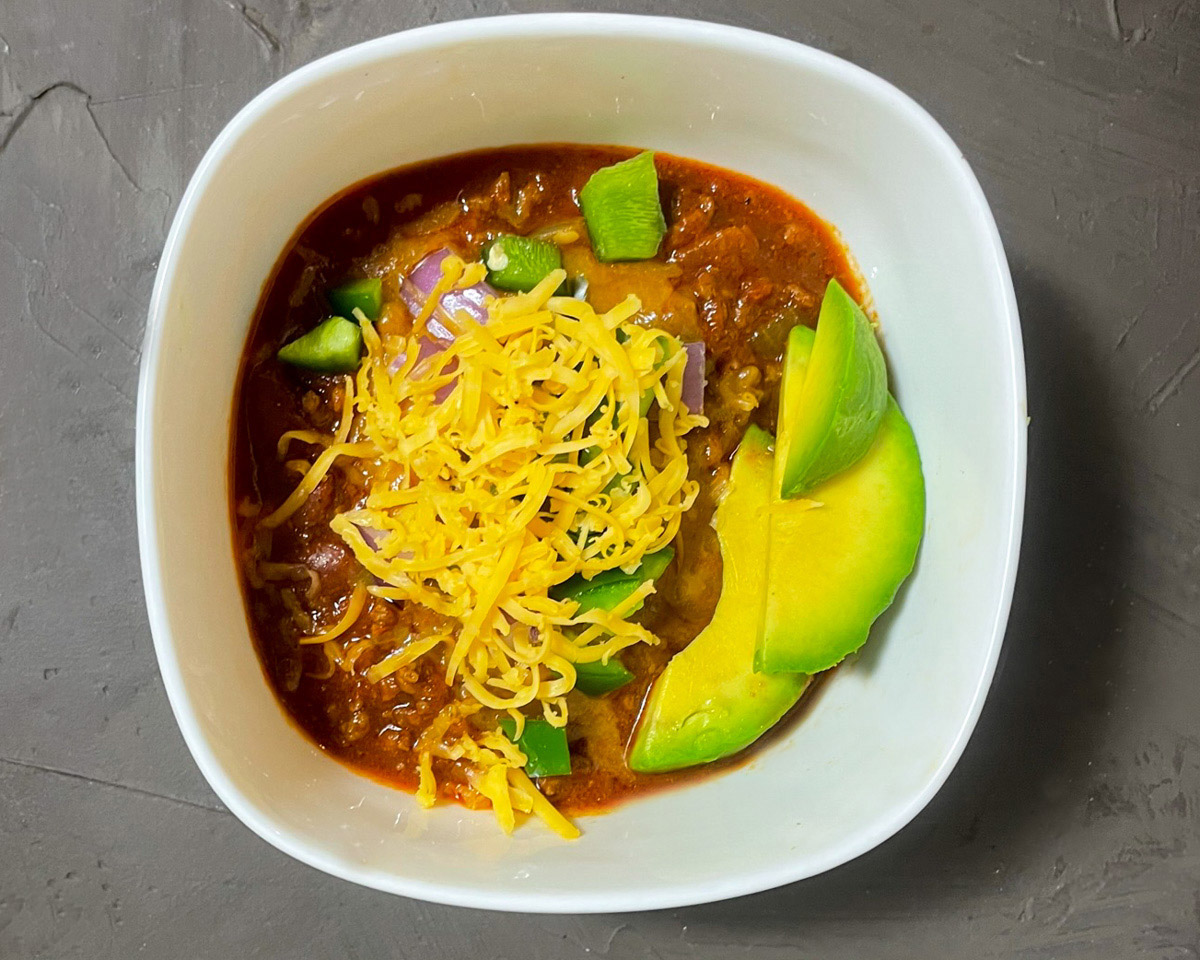 Texas Roadhouse Chili served with cheese, jalapeno peppers, avocado slices, and diced red onions