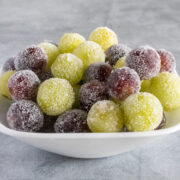 Candied green and red grapes in a white bowl