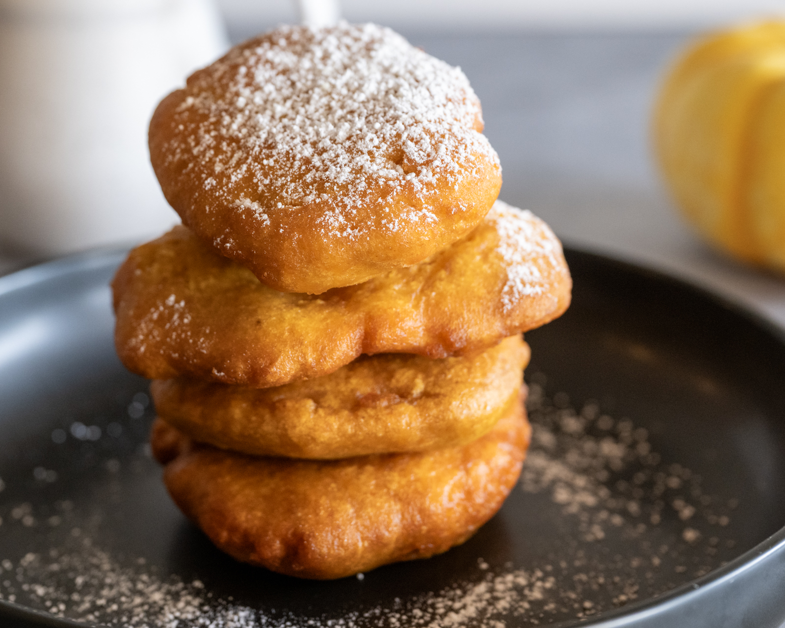 Seminole pumpkin frybread, 4 pieces stacked on a black plate.
