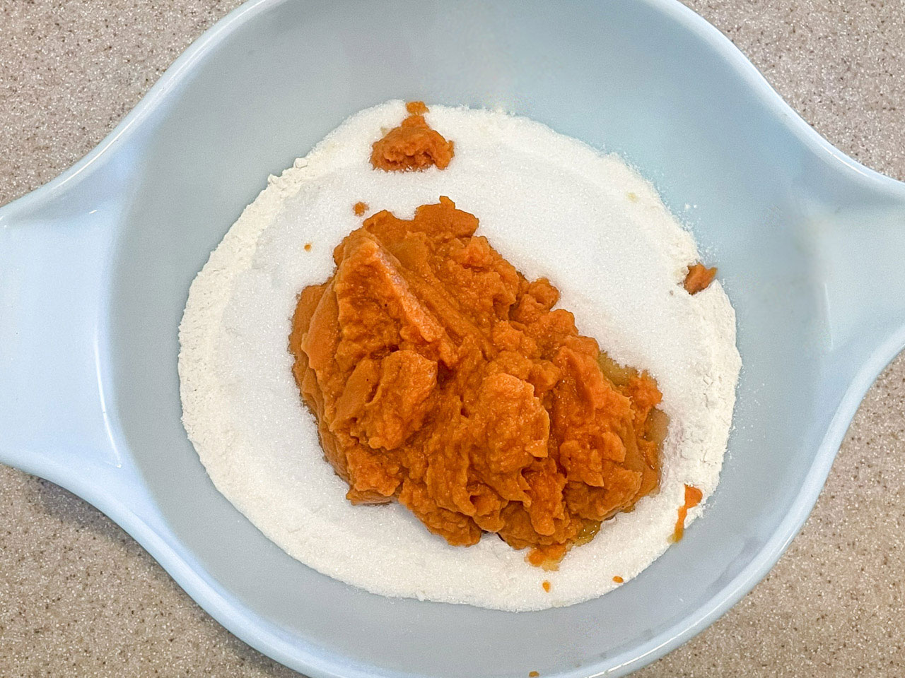Pumpkin, sugar, and flour in a mixing bowl