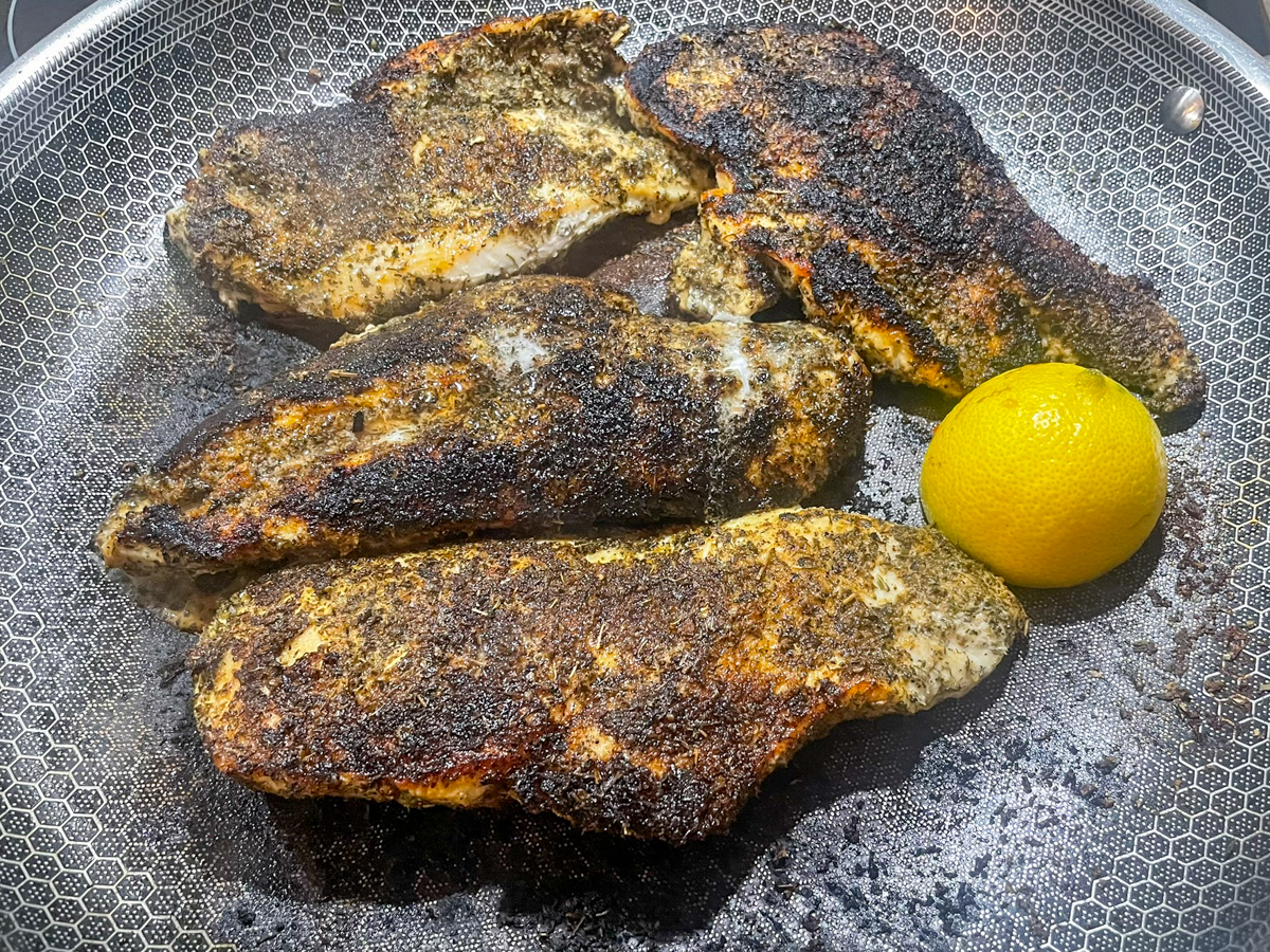 Chicken and lemon cooking in a skillet